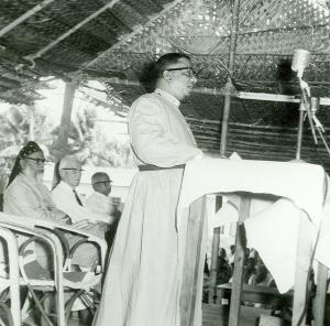 Bishop T. S. Joseph speaking at the Maramon Convention while Bishop Alexander Mar Theophilus (Metropolitan Alexander Mar Thoma), E. Stanley Jones and Mr. Ramenpillar listen.